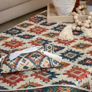 Ethnic-patterned tissue box cover placed on a wooden side table in a cozy living room.