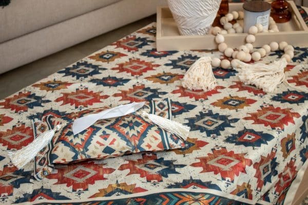 Ethnic-patterned tissue box cover placed on a wooden side table in a cozy living room.