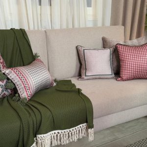 Baysan square cushion cover with traditional warm-toned patterns.