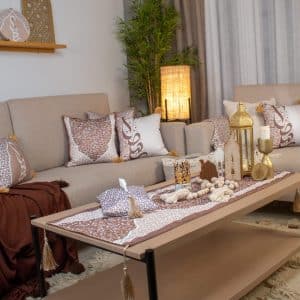 Decorative cushions with Arabic calligraphy and tassels from the 'أثر' collection in mocha tones.