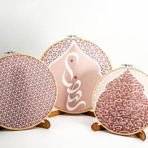 Wooden embroidery hoop set with Arabic calligraphy from the 'أثر' collection in mocha tones.
