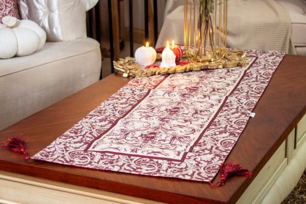 Luxurious burgundy dual-sided runner styled on a coffee table with candles and floral decor.