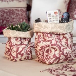 Elegant burgundy fabric storage boxes styled on a coffee table with matching home decor.