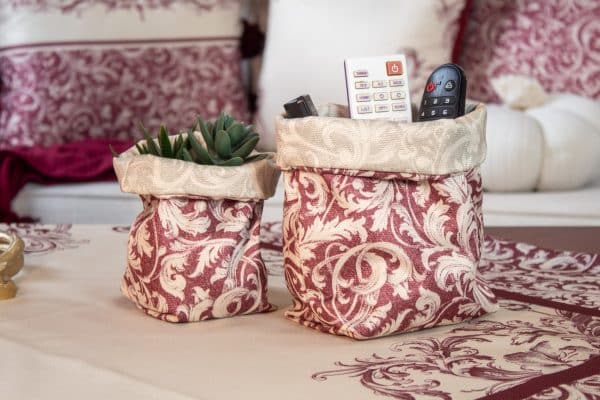 Elegant burgundy fabric storage boxes styled on a coffee table with matching home decor.