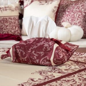 Burgundy tissue box cover styled on a side table with matching decor.