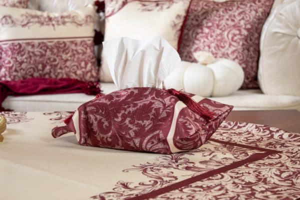 Burgundy tissue box cover styled on a side table with matching decor.