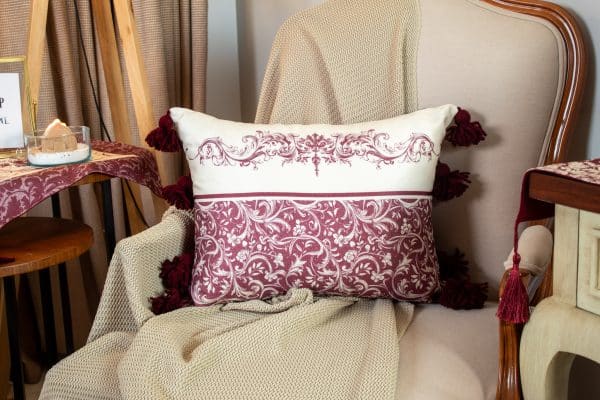 Burgundy patterned cushion cover styled on a sofa with matching decor.