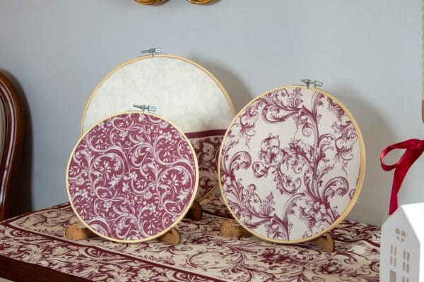 Set of burgundy decorative hoops displayed on a wall with matching decor accents.