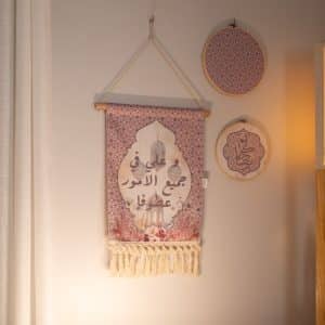 Wall hanging décor with floral patterns and Arabic calligraphy from the 'روبا' collection.