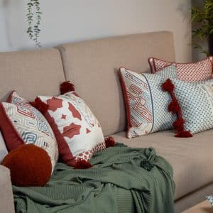 Decorative cushions with Kufic-inspired patterns and tassels from the 'كوفي' collection.