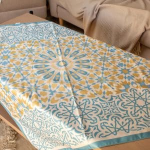 Square table cover from the 'نقوش' collection with geometric patterns, perfect for Ramadan gatherings.
