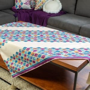 Square table cover with colorful abstract patterns from the 'طيف' collection.